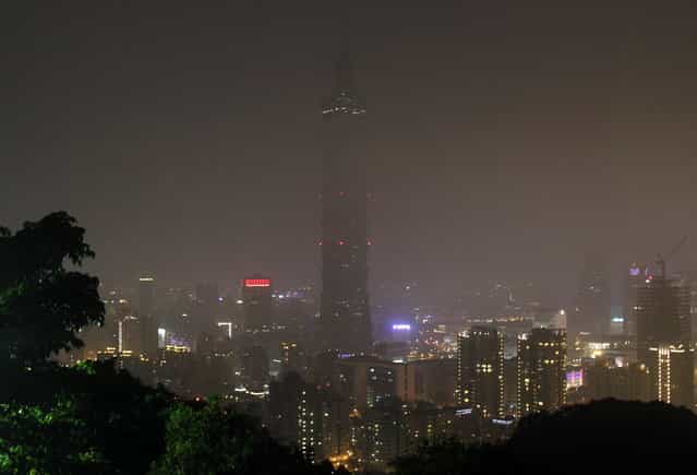 The Taipei 101 Building is seen darkened during the Earth Hour in Taipei, Taiwan, Saturday, March 23, 2013. Organised by the World Wide Fund for Nature, earth hour is observed every year to create awareness about conservation of energy and climate change. Around the world, people and organisations will be turning their lights off from 8:30 to 9:30 pm local time. (Photo by Chiang Ying-ying/AP Photo)