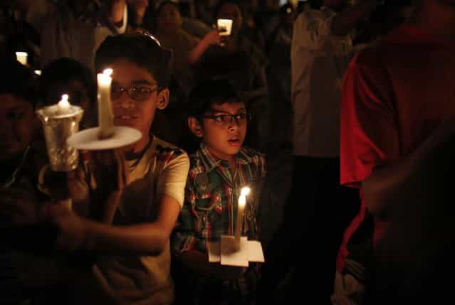 Children hold candles while participating in a candlelight vigil to mark Earth Hour in Mumbai March 23, 2013. Earth Hour, when everyone around the world is asked to turn off lights for an hour from 8.30 p.m. local time, is meant as a show of support for tougher actions to confront climate change. (Photo by Danish Siddiqui/Reuters)