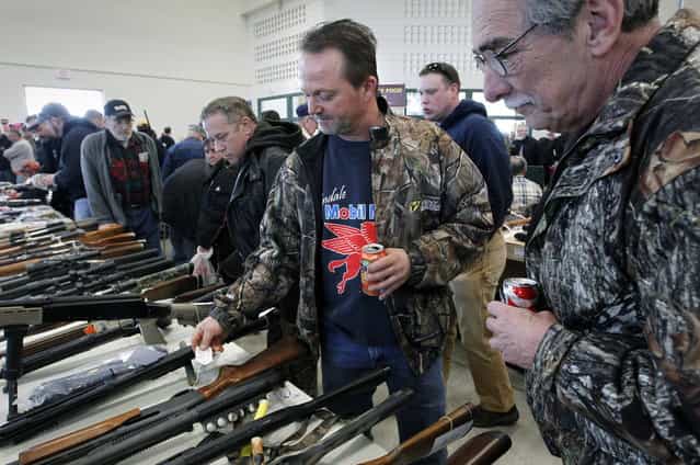 Rick Schaeffer, of Grafton, shops for a hunting rifle at the Washington County Fairgrounds Gun Show that drew thousands of people over the weekend, on March 22, 2013. (Photo by Gary Porter)
