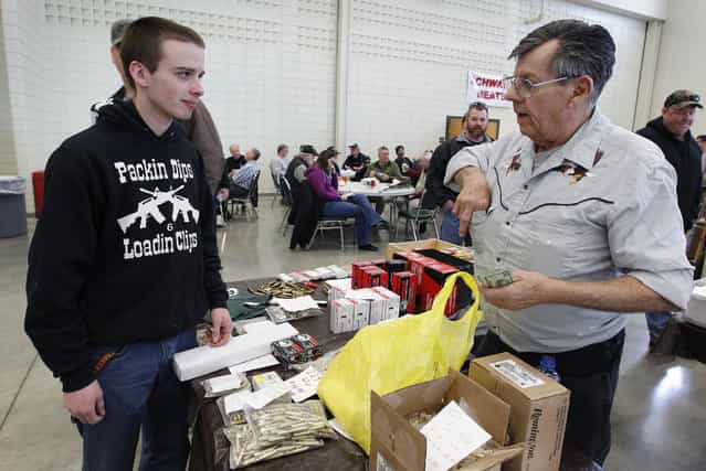 Roland Blanke, of Sheboygan Falls sells .223 gauge shells to Jeff Barelmann, of Cedarburg, that he says are becoming scarce because of Homeland Security, at the Washington County Fairgrounds Gun Show that drew thousands of people over the weekend, on March 22, 2013. (Photo by Gary Porter)