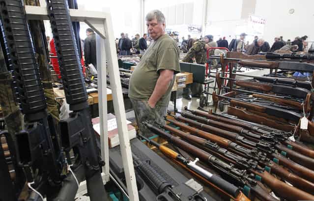 A man who asked that his name not be used watches over his inventory at the Washington County Fairgrounds Gun Show that drew thousands of people over the weekend, on March 22, 2013. (Photo by Gary Porter)