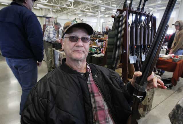 Robert Repinski, of Plover, brought a friends 20 gauge shotgun to try and sell at the Washington County Fairgrounds Gun Show that drew thousands of people over the weekend, on March 22, 2013. (Photo by Gary Porter)