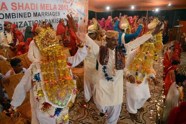 Pakistani grooms celebrate during a mass marriage ceremony in Karachi late March 26, 2013. Some 110 couples participated in the mass wedding ceremony organised by a local charity welfare trust Al Ghousia. (Photo by Asif Hassan/AFP Photo)