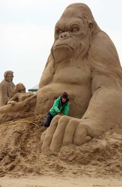 Sand sculptor Helena Bangert (C), from Holland works on a sand sculpture of King Kong as pieces are prepared as part of this year's Hollywood themed annual Weston-super-Mare Sand Sculpture festival on March 26, 2013 in Weston-Super-Mare, England. Due to open on Good Friday, currently twenty award winning sand sculptors from across the globe are working to create sand sculptures including Harry Potter, Marilyn Monroe and characters from the Star Wars films as part of the town's very own movie themed festival on the beach. (Photo by Matt Cardy)