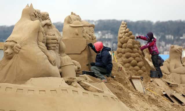 A sand sculptor works on a Toy Story themed sand sculpture as pieces are prepared as part of this year's Hollywood themed annual Weston-super-Mare Sand Sculpture festival on March 26, 2013 in Weston-Super-Mare, England. Due to open on Good Friday, currently twenty award winning sand sculptors from across the globe are working to create sand sculptures including Harry Potter, Marilyn Monroe and characters from the Star Wars films as part of the town's very own movie themed festival on the beach. (Photo by Matt Cardy)