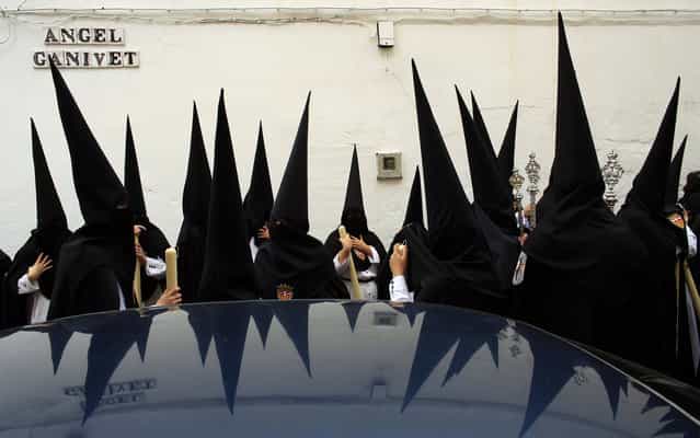 Penitents wait before taking part in the procession of [Santa Genoveva] brotherhood during Holy Week in the Andalusian capital of Seville, southern Spain, March 25, 2013. Hundreds of Easter processions take place around the clock in Spain during Holy Week, drawing thousands of visitors. (Photo by Marcelo del Pozo/Reuters)