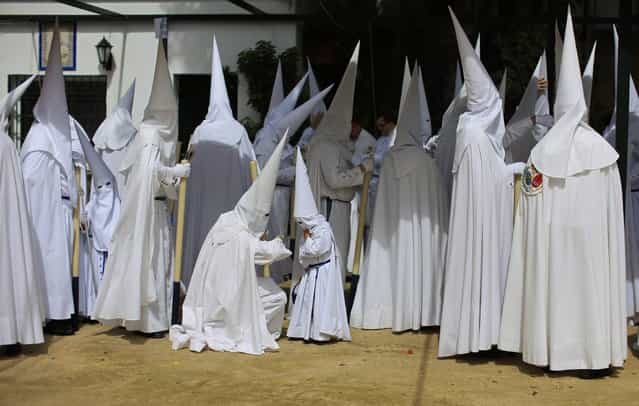 Penitents of [La Paz] (The Peace) brotherhood wait before their penance during Holy Week in the Andalusian capital of Seville, southern Spain, March 24, 2013. Hundreds of Easter processions take place around the clock in Spain during Holy Week, drawing thousands of visitors. (Photo by Marcelo del Pozo/Reuters)