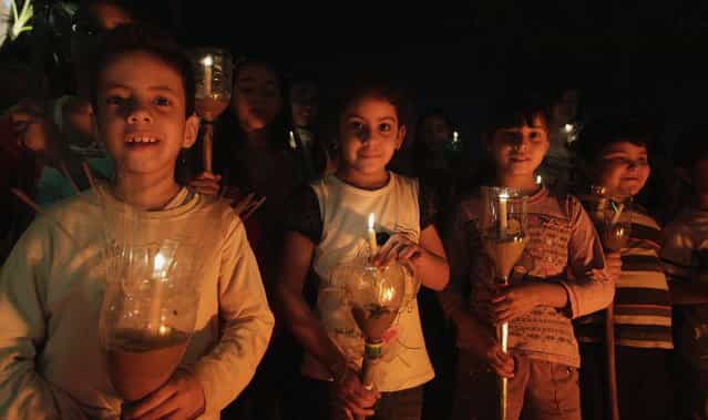 Catholic children hold candles during the [Via Crucis] (Way of the Cross) re-enactment in a procession during Holy Week, in preparation for Good Friday celebrations, in Luque March 27, 2013. Week is celebrated in many Christian traditions during the week before Easter. (Photo by Jorge Adorno/Reuters)