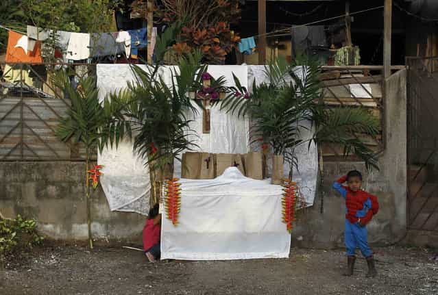 A boy dressed as Spider Man stands near an altar outside his house before a Holy Week procession in Tapachula, near San Jose, Costa Rica, on March 27, 2013. Holy Week is celebrated in many Christian traditions during the week before Easter. (Photo by Juan Carlos Ulate/Reuters)