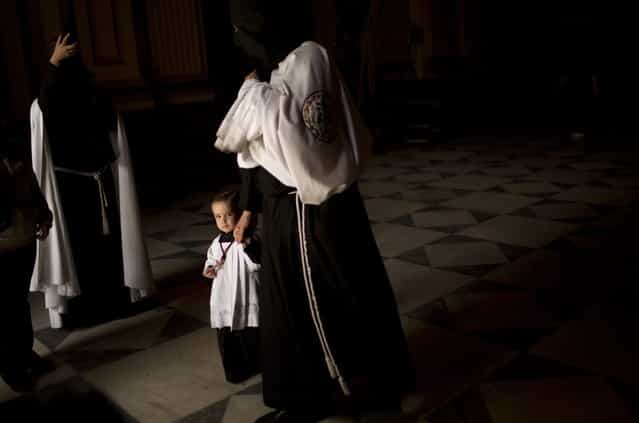 Penitents from [La Sed] brotherhood leave the church after the procession was cancelled due to bad weather in Seville, Spain, Wednesday, March 27, 2013. Most of the Eater Holy Week processions were canceled in Seville because of the rain Wednesday. (Photo by Emilio Morenatti/AP Photo)