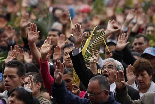 Faithful pray during a Palm Sunday Mass at the Baby Jesus Church in Bogota, Colombia, Sunday March 24, 2013. According to the New Testament, Palm Sunday marks the day Jesus rode into Jerusalem, greeted by cheering crowds bearing palm fronds. For Christians, Palm Sunday marks the start of Holy Week. The week continues with commemorations of Jesus' crucifixion on Good Friday before celebrating his resurrection on Easter the following Sunday. (Photo by Fernando Vergara/AP Photo)