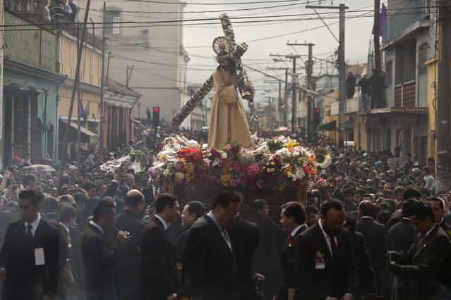 Parishioners parade the Jesús Nazareno de la Merced statue through downtown Guatemala City, in the annual Holy Tuesday procession known as [La Reseña], March 26, 2013. La Reseña or Review is one of the country's earliest Catholic processions, the first recorded in 1721. (Photo by Moises Castillo/AP Photo)