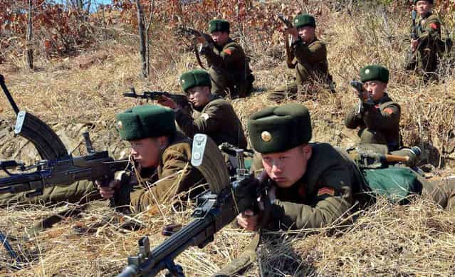 This picture, taken by North Korea's official Korean Central News Agency on March 20, 2013 shows North Korea's Korean People's Army soldiers at an undisclosed location in North Korea. Meanwhile, North Korea on March 21 threatened strikes on US military bases in Japan and Guam, escalating tensions as suspicion deepened that Pyongyang was behind a cyber attack on South Korean broadcasters and banks. (Photo by AFP Photo/KCNA via KNS)