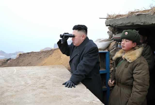 Kim Jong Un uses a pair of binoculars to look towards the South during his visit to the Jangjae Islet Defence Detachment and Mu Islet Hero Defence Detachment, southwest of Pyongyang, on March 7, 2013. (Photo by Reuters/KCNA)