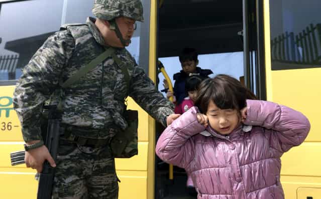 Elementary students exit a vehicle to enter a shelter during a civil defense drill against a possible attack by North Korea on Baeknyeong Island, close to North Korea, in the western waters of South Korea, Tuesday, March 19, 2013. The United States is flying nuclear-capable B-52 bombers on training missions over South Korea to highlight Washington's commitment to defend an ally amid rising tensions with North Korea, Pentagon officials said Monday. (Photo by Bae Jung-hyun/AP Photo/Yonhap)