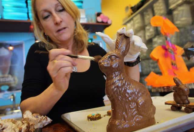 Darlene Eddy uses a brush to remove chocolate shavings from an Easter bunny that she made in her store Amazing Chocolates on March 28, 2013 in Hollywood, Florida. Americans spend roughly $1.9 billion on Easter candy, second only to Halloween in candy consumption. Around ninety million chocolate Easter bunnies are produced each year, from white to dark chocolate, and with an unlimited varieties of styles. (Photo by Joe Raedle)