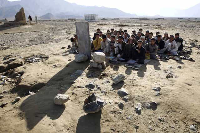 Afghan boys sit on the ground outdoors for their lesson, near Khas Kunar refugee camp, Kunar Province, eastern Afghanistan February 18, 2009. (Photo by Oleg Popov/Reuters)