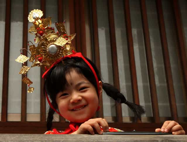 A young girl wears a traditional costume to take a part in the Ochiogosan parade during the Mitsuyama Taisai Festival of Itate Hyozu Shrine at Shirahama on March 31, 2013 in Himeji, Japan. The festival has been held once every 20 years since 1593. Priests of the Itate Hyozu Shrine welcome all the gods across the country from the top of 'three mountains' and treat with food for seven days starting today, praying for peace and prosperity. (Photo by Buddhika Weerasinghe)