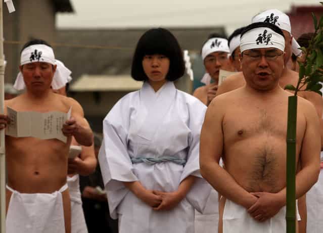 Shrine priests pray whiile bathing in sea water before attending a ritual during the Mitsuyama Taisai Festival at the Itate Hyozu Shrine in Shirahama on March 31, 2013 in Himeji, Japan. The festival has been held once every 20 years since 1593. Priests of the Itate Hyozu Shrine welcome all the gods across the country from the top of 'three mountains' and treat with food for seven days starting today, praying for peace and prosperity. (Photo by Buddhika Weerasinghe)
