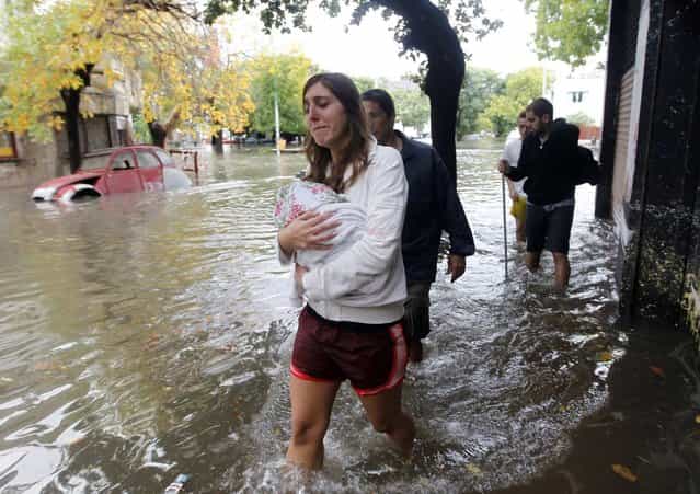People wade through a flooded street after a rainstorm in Buenos Aires April 2, 2013. Thunderstorms damaged property and vehicles, cut power and caused delays on flights in Buenos Aires and its suburbs. The City's SAME emergency service announced that the death toll has risen to five. (Photo by Enrique Marcarian/Reuters)