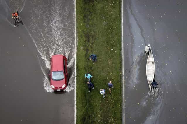 An aerial view of a boat and a car on a flooded street after heavy rains flooded a large part of the city, is pictured in La Plata April 3, 2013. At least 46 people were killed in Argentina on Wednesday after a torrential downpour battered the eastern city of La Plata and forced some 2,200 people to flee their homes in search of dry ground. (Photo by Reuters/Infobae.com)