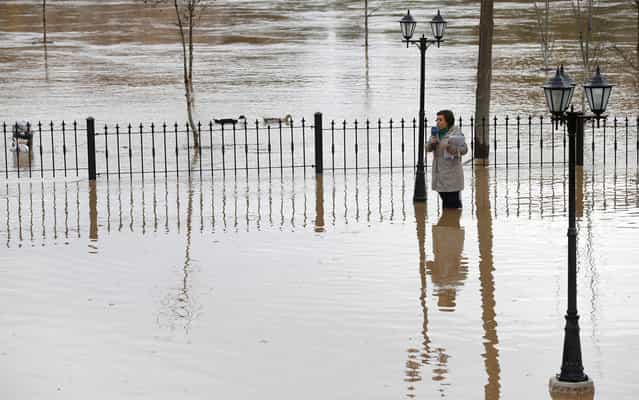 A television journalist standing in floodwaters reports the situation in Tordesillas after the Duero river overflowed its banks on April 1, 2013. Spain suffered its wettest March since 1947, according to information released by the Spanish meteorological agency AEMET. (Photo by Cesar Manso/AFP Photo)
