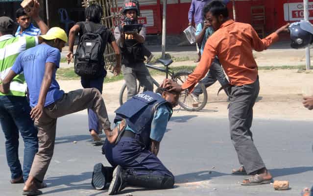 Students wings of Bangladesh Jamaat-e-Islam beat a police officer Jahangir Alam in the northwestern city of Rajshahi, about 260 kms from the capital Dhaka, on April 1, 2013. At least four policemen were injured, one critically, and a firearm and a walkie-talkie were snatched from them when Jamaat-e-Islami activists and its student wing Islami Chhatra Shibir clashed with police in Rajshahi city on Monday morning, local media reported. (Photo by AFP Photo)