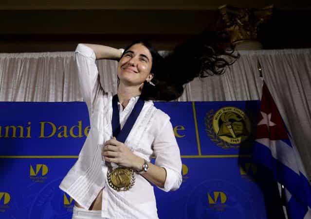 Blogger and activist Yoani Sanchez of Cuba adjusts her hair after receiving a medal from Miami Dade College president Eduardo Padron, after speaking at the Freedom Tower of Miami Dade College, on April 1, 2013. Sanchez has gained thousands of followers worldwide for her candid descriptions of modern life in Cuba on her blog Generation Y. (Photo by Lynne Sladky/Associated Press)
