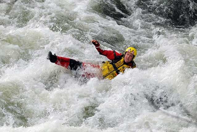A Bowling Green, Ky., firefighter careens through the rapids of the Barren River after trying to assist in the rescue of two teenage fishermen who were stranded in the rapids after their boat overturned, on April 1, 2013. The fishermen were rescued after two hours and the firefighter was transported to the Medical Center with unknown injuries. (Photo by Joe Imel/Daily News)
