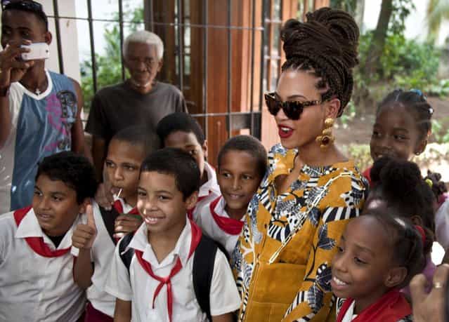U.S. singer Beyonce poses for photos with school children as she tours Old Havana, Cuba, Thursday, April 4, 2013. Beyonce is in Havana with her husband, rapper Jay-Z, on their fifth wedding anniversary. (Photo by Ramon Espinosa/AP Photo)