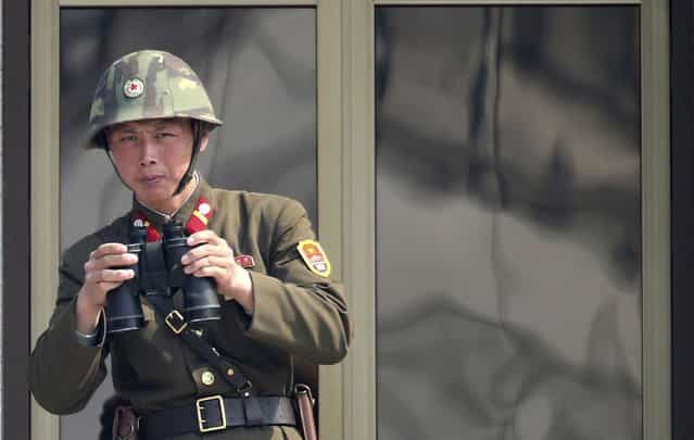 A North Korean soldier watches the South Korean side at the border village of Panmunjom in the demilitarized zone (DMZ) in South Korea Thursday, April 4, 2013. South Korea's defense minister said Thursday North Korea has moved a missile with [considerable range] to its east coast, but said it is not capable of hitting the United States. (Photo by Lee Jong-hoon/AP Photo/Yonhap)