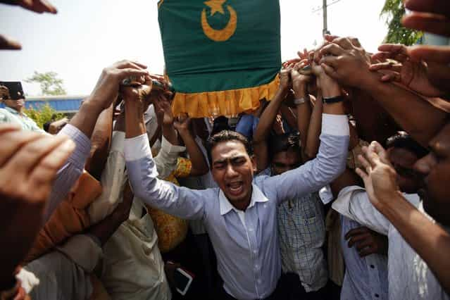 People carry a coffin during a funeral for the victims of a fire at Yaeway cemetery in Yangon April 2, 2013. Thousands of Muslims attended the funeral for the 13 victims of the fire that broke out in a dormitory of an Islamic school in the central, multi-ethnic Botataung district of the former capital. The fire caused by faulty electrical equipment killed 13 boys at the school in Yangon on Tuesday, the fire service said. (Photo by Minzayar/Reuters)