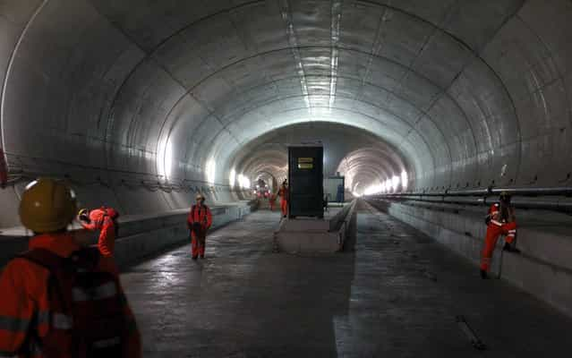 Journalists take pictures during their visit to the construction site in the NEAT Gotthard Base tunnel near Sedrun April 2, 2013. Crossing the Alps, the world's longest train tunnel should become operational at the end of 2016. The project consists of two parallel single track tunnels, each of a length of 57 km (35 miles). (Photo by Arnd Wiegmann/Reuters)