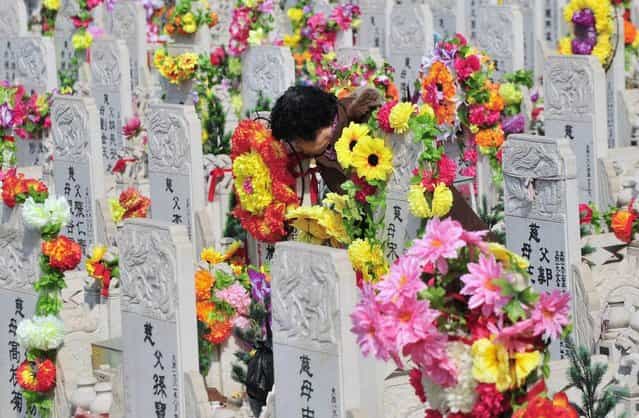 A resident leans her face against the tombstone of a deceased relative at a public cemetery a day ahead of the Qingming Festival, or Tomb Sweeping Day, in Shenyang, Liaoning province of China, April 3, 2013. The festival, which falls on April 4 this year, is a day for the Chinese to remember and honour one's ancestors. According Xinhua News Agency, the Ministry of Civil Affairs has issued China's first service standard for public cemeteries to better regulate an industry that faces increasing pressure with China's ageing society. (Photo by Reuters/Stringer)