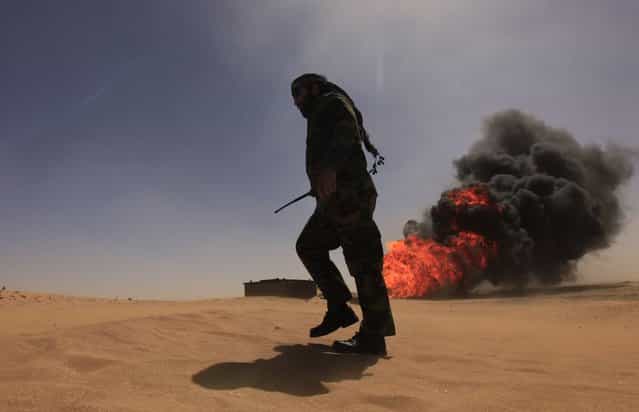 A security officer walks past a gas pipeline after an explosion, 18 km (11 miles) south of the city of Ajdabiyah April 3, 2013. Libya is investigating the cause of the explosion late on Tuesday on oil and condensate pipelines to the eastern port of Zueitina, the National Oil Corporation (NOC) said. It quoted acting NOC Chairman Abdulkasir Shengir as saying there were no casualties. (Photo by Esam Al-Fetori/Reuters)