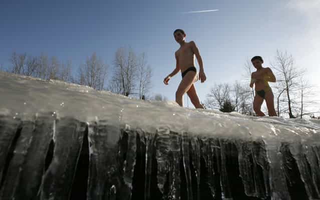 Members of a local winter swimming club brothers Alexander (L), 13, and Georgy, 10, Gliskov walk along a frozen bank after bathing in the icy waters of the Yenisei River in Krasnoayrsk, Russia, on April 3, 2013. (Photo by Ilya Naymushin/Reuters)