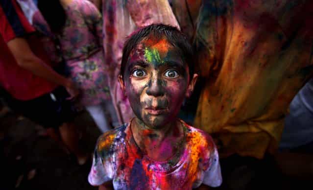 A boy, his face smeared with colored powder, reacts as he poses for a photo during a celebration of the Hindu festival Holi in Kuala Lumpur, Malaysia, on March 31, 2013. (Photo by Seng Sin/Associated Press)