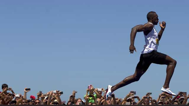 Jamaican Olympic gold medallist Usain Bolt wins the [Mano a Mano] men's 150m challenge on Copacabana beach in Rio de Janeiro, on March 31, 2013. Bolt defeated Antigua and Barbuda's Daniel Bailey, Ecuador's Alex Quinones and Brazil's Bruno Lins de Barros on a track specially built at the famous beach. (Photo by Felipe Dana/Associated Press)