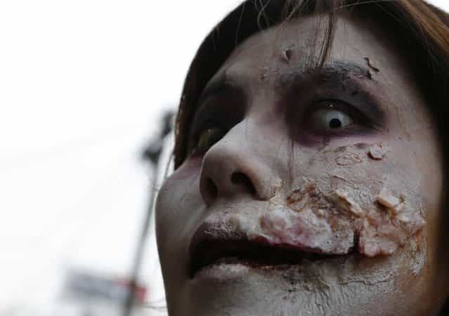 Jurina Oguchi, a 37-year-old office worker who is dressed as a zombie, poses for a photo before the Roppongi Zombie Walk in Tokyo March 31, 2013. About 50 people dressed up as zombies early evening on Sunday, catching the attention of pedestrians on the streets of Tokyo's downtown Roppongi district. (Photo by Yuya Shino/Reuters)