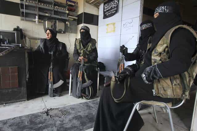 Women members of the Al-Ikhlas (Loyalty) Battalion rest with their weapons in Aleppo March 31, 2013. The Al-Ikhlas (Loyalty) Battalion is a security battalion that involves women that are in charge of erecting sudden checkpoints and raiding houses that contain women in Aleppo. The battalion is under the Ghorabaa (Strangers) Al-Sham Front, controlled by the Free Syrian Army. (Photo by Giath Taha/Reuters)