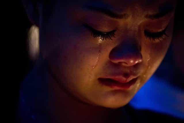 A fan of the late Hong Kong canto-pop star Leslie Cheung cries during a candlelight vigil in Hong Kong April 1, 2013. Exhibitions, concerts and tribute events are held in Hong Kong to mark the 10th anniversary of the death of Cheung, who leapt to his death from a hotel on April 1, 2003. (Photo by Tyrone Siu/Reuters)