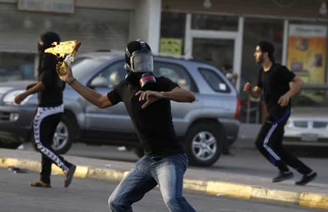 A protester throws a Molotov cocktail at riot police during clashes at an anti-government protest in the village of Diraz west of Manama, Bahrain, April 1, 2013. (Photo by Hamad I Mohammed/Reuters)