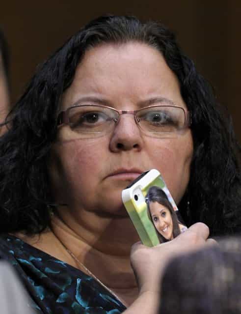 Donna Soto, mother of slain Sandy Hook Elementary teacher Victoria Soto, holds here phone with a photo of her daughter on it while she listens to testimony on Capitol Hill in Washington, Wednesday, February 27, 2013, during the Senate Judiciary Committee on the Assault Weapons Ban of 2013. (Photo by Susan Walsh/AP Photo)