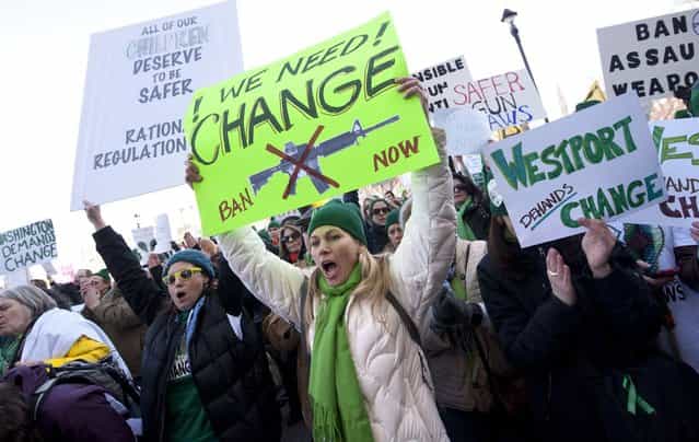Demonstrators yell and hold up signs during a rally at the Capitol in Hartford, Conn., Thursday, February 14, 2013. Thousands of people turned out to call on lawmakers to toughen gun laws in light of the December elementary school shooting in Newtown that left 26 students and educators dead. (Photo by Jessica Hill/AP Photo)