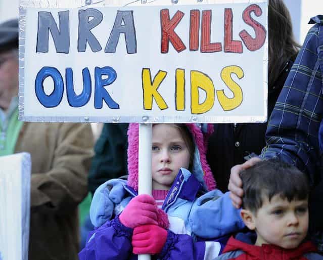 Abigail Garrett of Hampden holds a saign during a rally at the Capitol in Hartford, Conn., Thursday, February 14, 2013. Thousands of people turned out to call on lawmakers to toughen gun laws in light of the December elementary school shooting in Newtown that left 26 students and educators dead. (Photo by Jessica Hill/AP Photo)