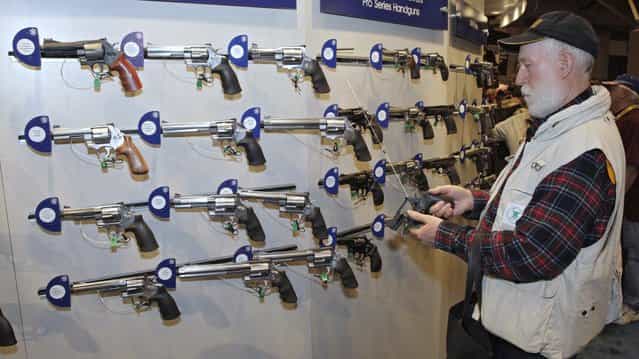 Homer Van Meter, of Rhineland, WI, inspects a revolver during the National Rifle Association's (NRA) 141st Annual Meetings & Exhibits in St. Louis, Missouri, April 13, 2012. (Photo by Tom Gannam/Reuters)