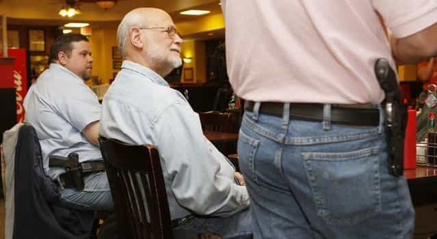 Bryan Hull (R), founding director of the Oklahoma Open Carry Association (OKOCA), and Tim Gillespie, director of Oklahoma Second Amendment Association, wear unconcealed side arms as Richard Prawdzienski (C) listens to Hull addressing OKOCA members gathered at Beverly's Pancake House in Oklahoma City November 1, 2012. A new Oklahoma law took effect November 1 allowing anyone with a concealed weapon license to carry their firearms openly in a holster or belt. (Photo by Bill Waugh/Reuters)