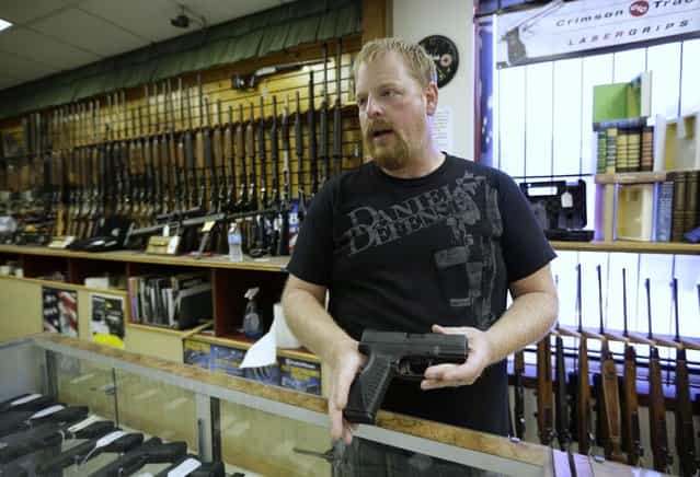 Eric Grabowski holds a hand gun, very similar to the gun used by alleged gunman Wade Michael Page, in The Shooter Shop, where Page purchased the weapon, in West Allis, Wisconsin, August 7, 2012. The gun used in the crime was the crime was identical, only it had a shorter barrel. The semiautomatic handgun used in the deadly attack on a Wisconsin Sikh temple is the same type used in other recent U.S. mass shootings, including one at a theater in Colorado, and the attack on a congresswoman in Arizona, gun experts said. (Photo by John Gress/Reuters)