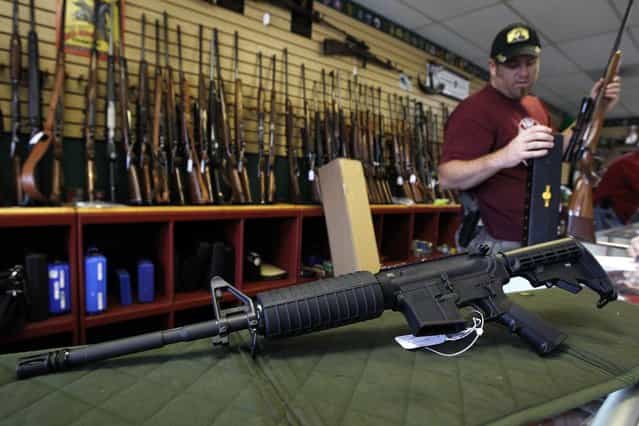 A Palmetto M4 assault rifle is seen at the Rocky Mountain Guns and Ammo store in Parker, Colorado July 24, 2012. The killing of 12 people at a midnight screening of the new Batman movie in the Denver suburb of Aurora may spark a fresh round of soul-searching on America's relationship with guns but few predict any real change in the law. (Photo by Shannon Stapleton/Reuters)
