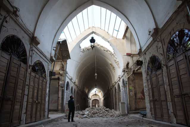 A resident inspects the damages at an ancient Souk caused by what activists said was shelling by forces loyal to Syria's President Bashar al-Assad in Deir al-Zor, on March 9, 2013. (Photo by Khalil Ashawi/Reuters /The Atlantic)